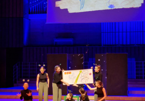 Aktorzy z planszą z narysowanymi znakami