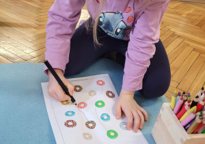 Dziewczynka szuka drugiej połowy takiego samego pączka