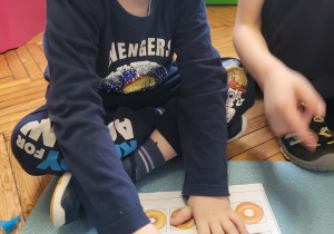 Chłopiec zaznacza pączka, kóry nie pasuje