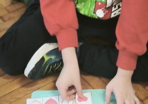 Chłopiec nakleja czerwone serce