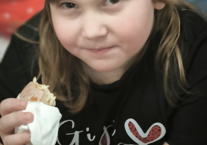 Dziewczynka je pączka