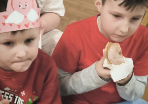 Chłopcy jedzą pączki