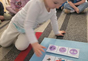 Dziewczynka układa znacznik obok sylwety papugi