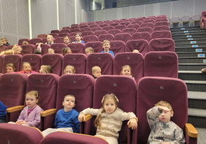 Dzieci siedza w sali kinowej
