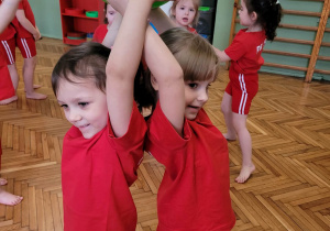 Dzieci trzymają mw parze balona w górze