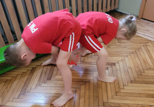 Dzieci podają sobie w parze balon między nogami