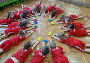 Dzieci leżą na podłodze z woreczkami