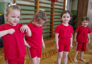 Dzieci stoją i oddychają głęboko po skończonych zabawach ruchowych