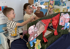 Dzieci z sylwetami bohaterów bajki 3 świnki
