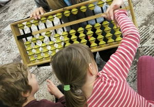 Dziewczynka przeklada krążki w liczydle