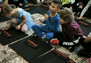 Dzieci na dywanie z liczydłami