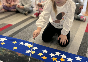 Dziewczynka pokazuje planetę Ziemia