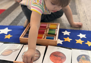 Dziewczynka kładzie różowy kolor obok planety