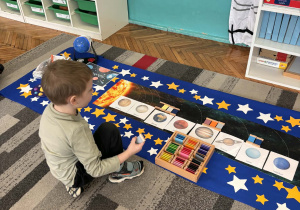 Chłopiec trzyma w ręku szary kolor