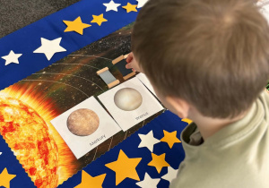 Chłopiec przyklada czarny kolor do planety