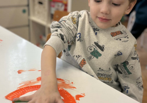 Chłopiec odciskuje rękę na talerzyku