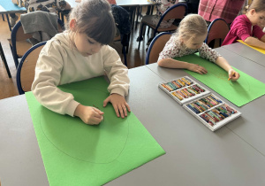 Dziewczynki na kartonach zielonych malują króliki