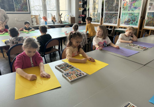 Dziewczynki na żółtych kartonach malują króliki