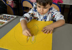 Chlopiec rysuje uszy królika