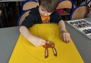 Chłopiec na brązowo maluje pyszczek królika