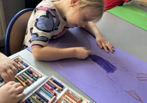 Dziewcyznka kolorouje na niebiesko królika