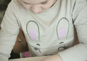 Dziewczynka koloruje dinozaura