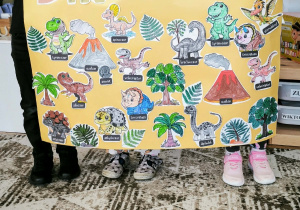 Dzieci z plakatem dinozaurów