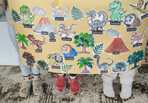 Dzieci z prehistorycznym plakatem z dinozaurami