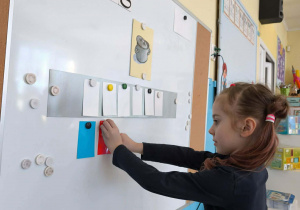 Dziewczynka przykleja kafelek z samogłoską a