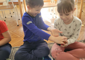 Chłopiec przekazuje kulkę wełny koleżance