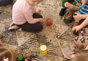 Dzieci segregują kolory włóczki do odpowiednich słoików z emocjami