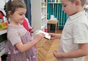 Chłopiec podaje dziewczynce prezent