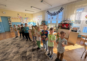 Chłopcy z kwiatkami stoją w rzędzie