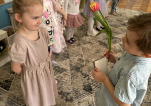 Chłopiec wręcza dziewczynce tulipana