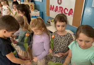 Chłopcy podają dziewczynkom skarbonki