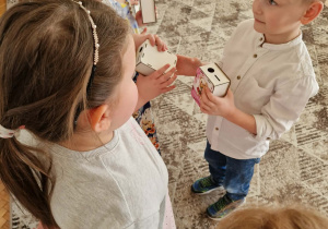 Chłopiec wręcza dziewczynce prezent skarbonkę