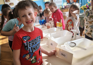 Chłopiec trzyma w ręku napis olej