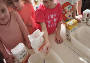 Dziewczynka wsypuje mąkę