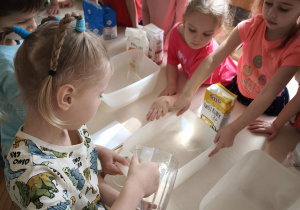 Chłopiec wlewa wodę do pojemnika