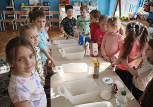 Dzieci stoją przed pustymi pojemnikami