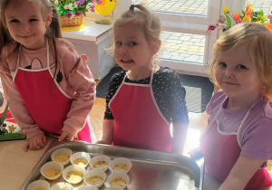 dziewczynki stoją przed babeczkami