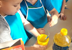 chłopcy wlewają olej