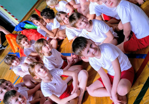 Dzieci siedza w kole w kostiumach gimnastycznych