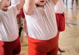 Dzieci stoją z rękoma w górze