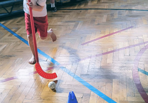 Chłopiec biegnie z kijem do hokeja