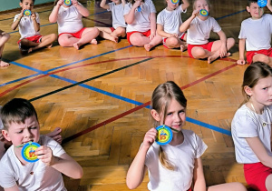 Dzieci siedzą z medalami