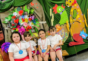 Dzieci siedzą pod dekoracją wielkanocną