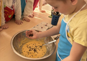 Chłopiec wsypuje kawałki czekolady
