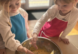 Dziewczynki dodają kawalki czekolady do miski