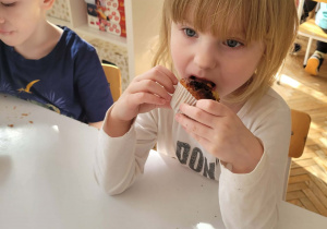 Dziewczynka je babeczkę